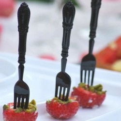 Des mini fourchettes de couleurs noires plantées dans des mises en bouches.